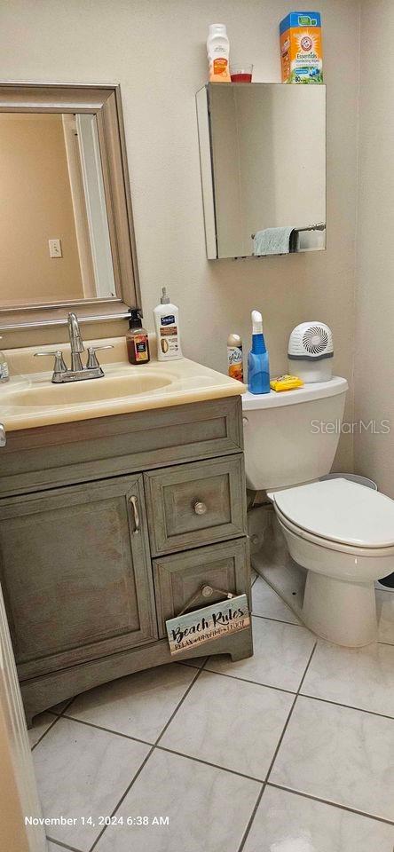 bathroom with tile patterned flooring, vanity, and toilet