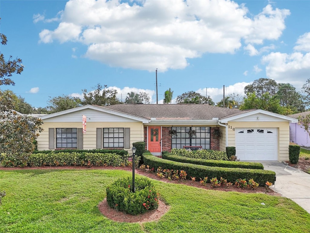 single story home with a garage and a front lawn