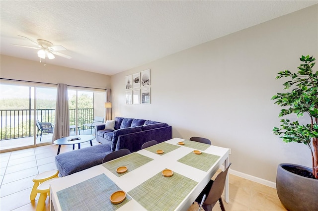 dining area featuring ceiling fan, light tile patterned floors, and a textured ceiling