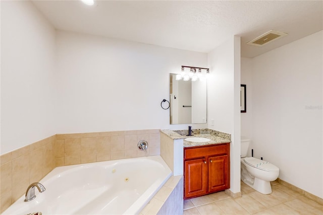 bathroom with tile patterned floors, tiled tub, a textured ceiling, toilet, and vanity