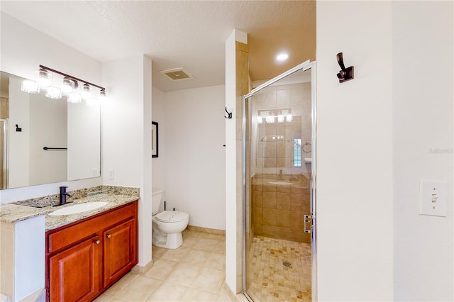 bathroom with a textured ceiling, vanity, a shower with door, tile patterned flooring, and toilet