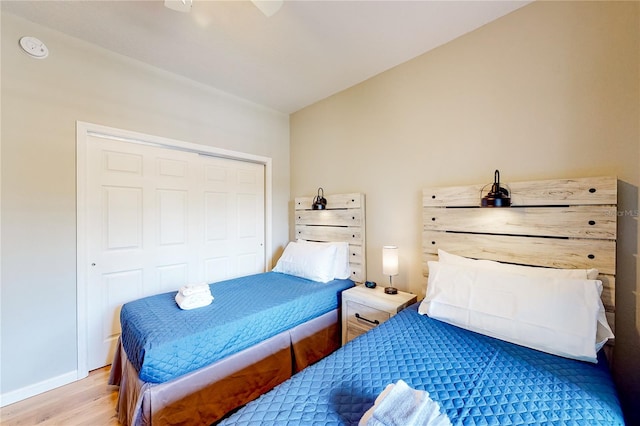 bedroom featuring ceiling fan, light wood-type flooring, and a closet