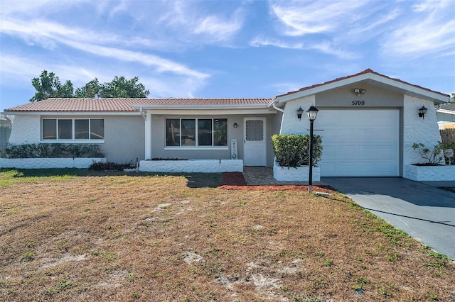 ranch-style home with a front yard and a garage