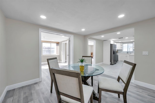 dining room featuring light wood-type flooring and plenty of natural light