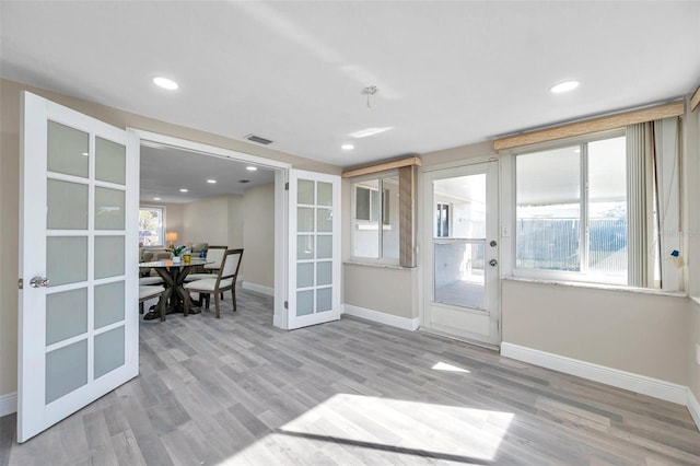 doorway to outside with plenty of natural light, light wood-type flooring, and french doors