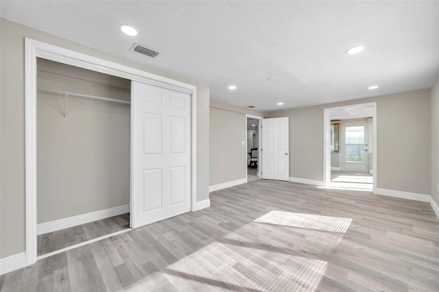 unfurnished bedroom featuring light wood-type flooring and a closet