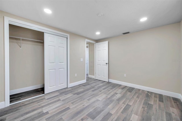 unfurnished bedroom featuring light wood-type flooring and a closet