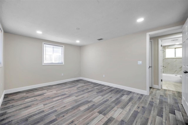 unfurnished room with wood-type flooring and a textured ceiling