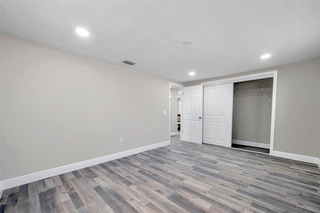 unfurnished bedroom featuring wood-type flooring, a textured ceiling, and a closet