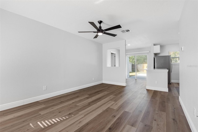 unfurnished living room with ceiling fan and dark wood-type flooring