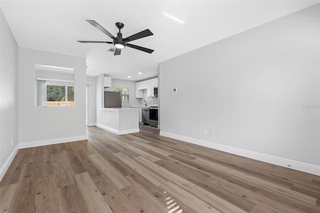 unfurnished living room featuring ceiling fan and light hardwood / wood-style flooring