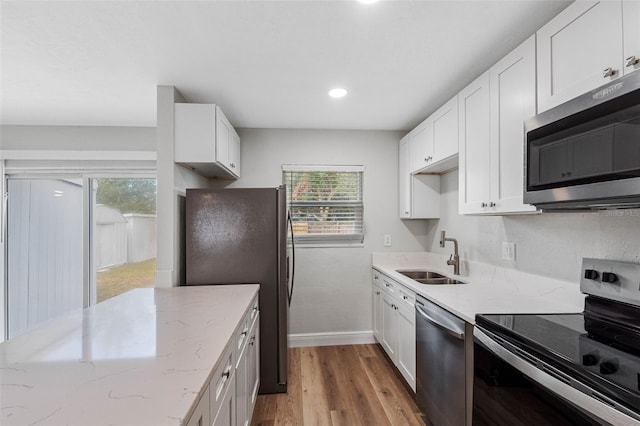 kitchen featuring stainless steel appliances, white cabinetry, and sink