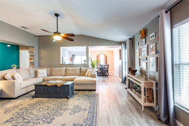 living room with wood-type flooring, vaulted ceiling, and ceiling fan