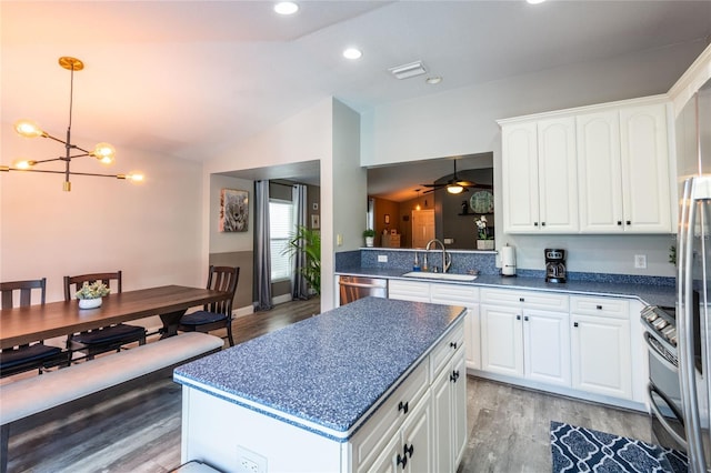 kitchen featuring sink, vaulted ceiling, white cabinets, ceiling fan with notable chandelier, and hardwood / wood-style flooring