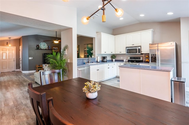 kitchen featuring sink, light wood-type flooring, lofted ceiling, and appliances with stainless steel finishes