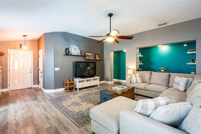 living room with hardwood / wood-style flooring, ceiling fan, and lofted ceiling