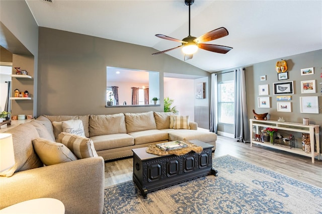 living room featuring ceiling fan, wood-type flooring, and vaulted ceiling