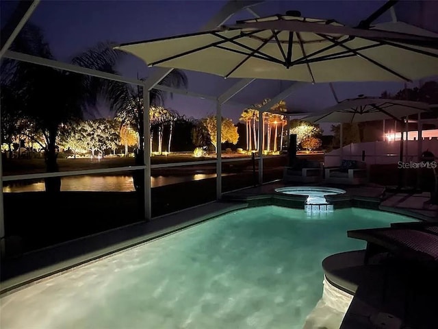 pool at twilight with glass enclosure and an in ground hot tub