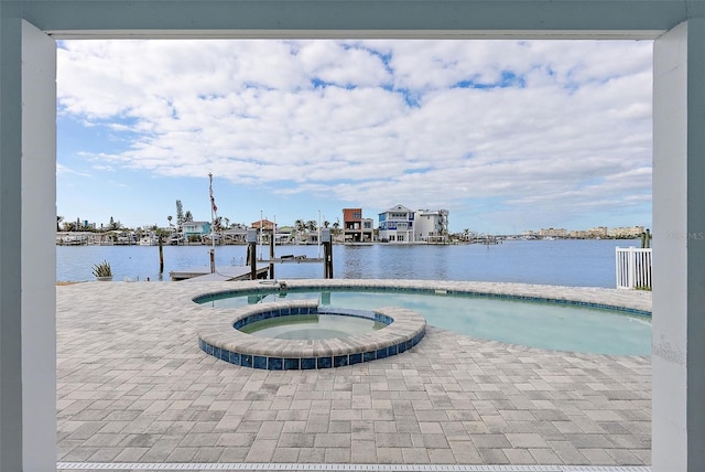 view of swimming pool featuring a water view, an in ground hot tub, and a dock