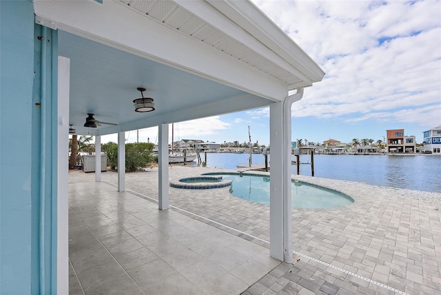 view of swimming pool with an in ground hot tub, ceiling fan, a water view, and a patio