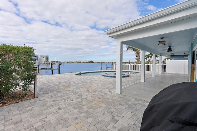 view of patio featuring ceiling fan, a dock, grilling area, a water view, and a swimming pool with hot tub