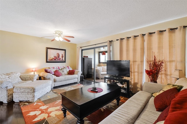 living room with ceiling fan, hardwood / wood-style floors, and a textured ceiling