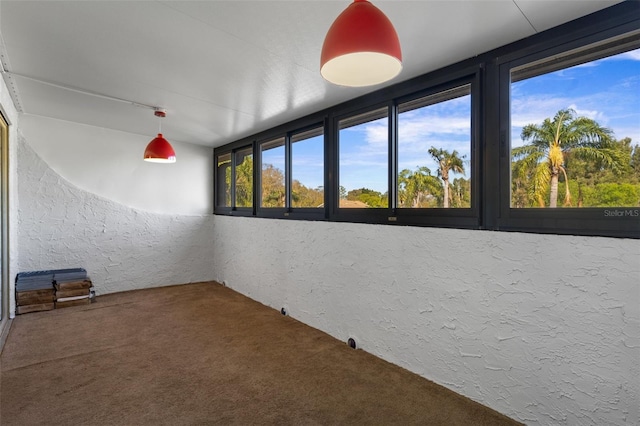 unfurnished room featuring carpet flooring and a textured wall