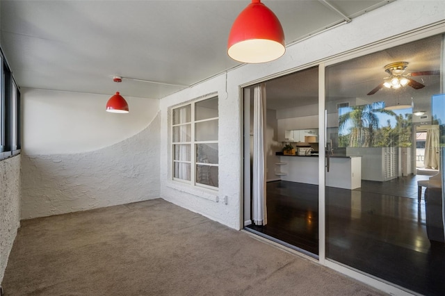 unfurnished sunroom with a ceiling fan