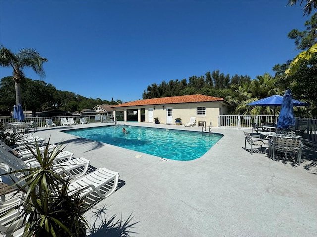 pool with a patio area and fence