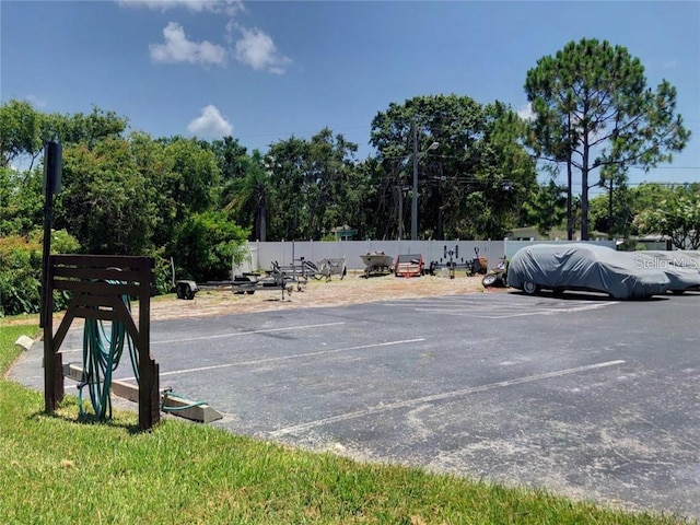 uncovered parking lot featuring fence