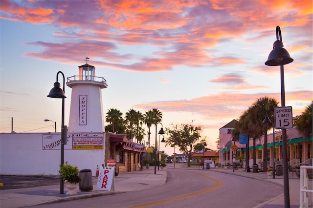 view of street featuring sidewalks, curbs, street lights, and traffic signs