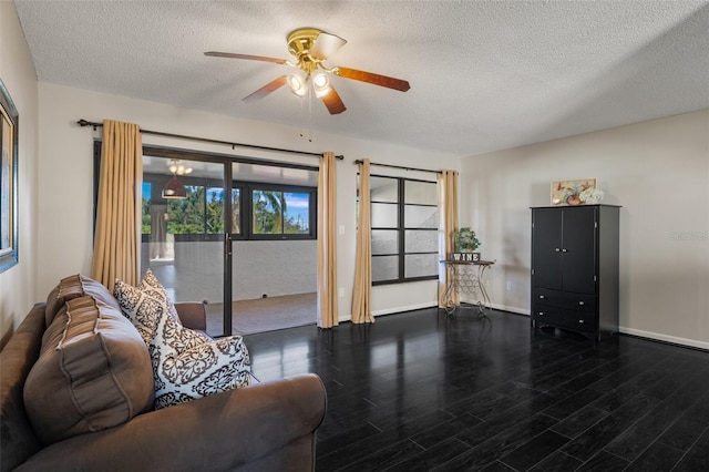 living area with ceiling fan, a textured ceiling, baseboards, and wood finished floors