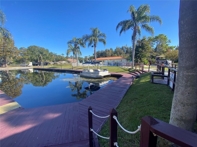 dock area with a yard and a water view