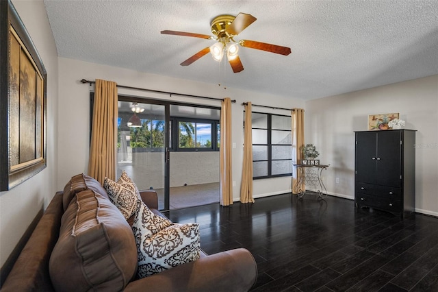 living room featuring a textured ceiling, a ceiling fan, baseboards, and wood finished floors