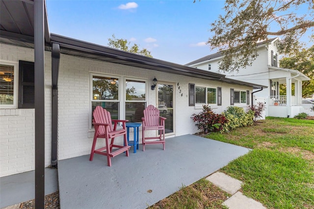 exterior space with a porch, a patio, and a lawn