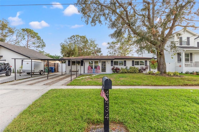 view of front of home with a front yard and a carport