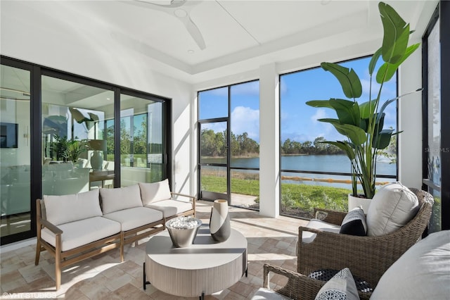 sunroom / solarium with ceiling fan and a water view