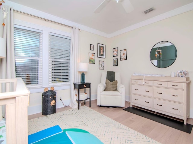 bedroom featuring light hardwood / wood-style flooring, ornamental molding, and ceiling fan