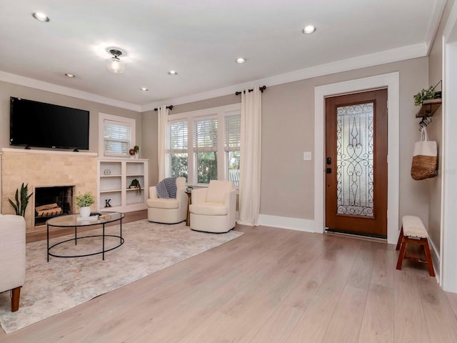 living room featuring ornamental molding, light hardwood / wood-style floors, and a brick fireplace