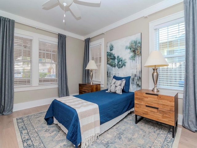 bedroom with hardwood / wood-style flooring, ceiling fan, and ornamental molding