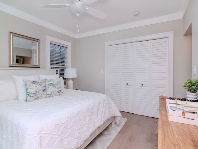 bedroom with light hardwood / wood-style flooring, ornamental molding, a closet, and ceiling fan