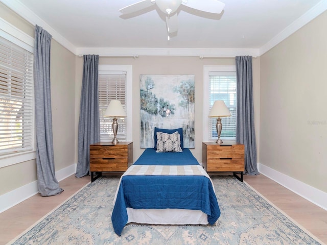 bedroom featuring wood-type flooring, ornamental molding, and ceiling fan