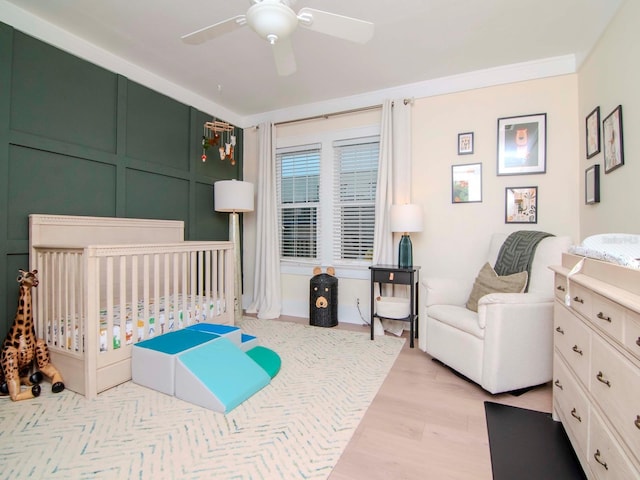 bedroom with ceiling fan, ornamental molding, and light hardwood / wood-style floors