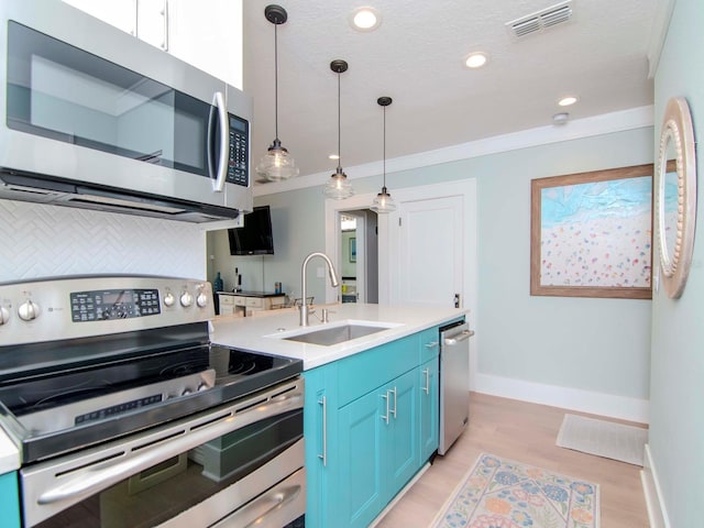 kitchen featuring sink, appliances with stainless steel finishes, hanging light fixtures, backsplash, and blue cabinets