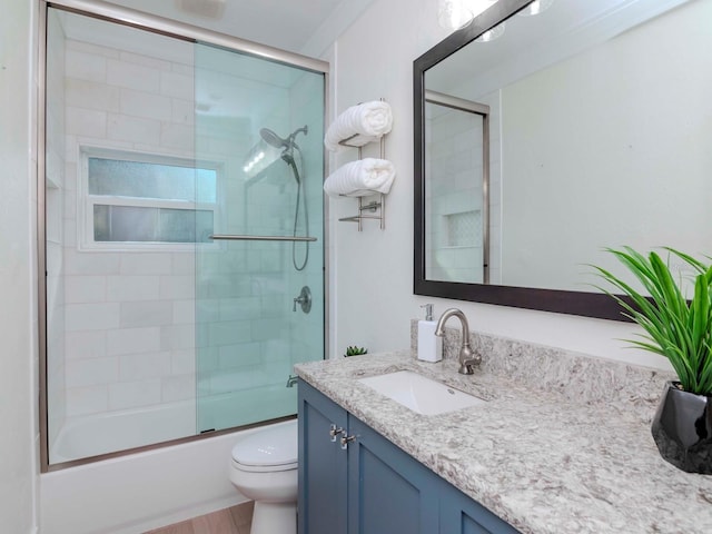 full bathroom with toilet, vanity, and bath / shower combo with glass door