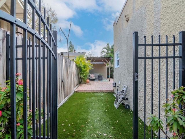 exterior space with an outdoor living space, a pergola, a patio area, and a lawn