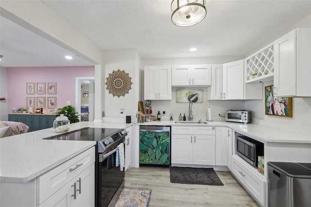 kitchen with kitchen peninsula, white cabinetry, sink, and stainless steel appliances