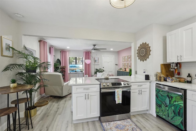 kitchen featuring kitchen peninsula, ceiling fan, appliances with stainless steel finishes, light hardwood / wood-style floors, and white cabinetry