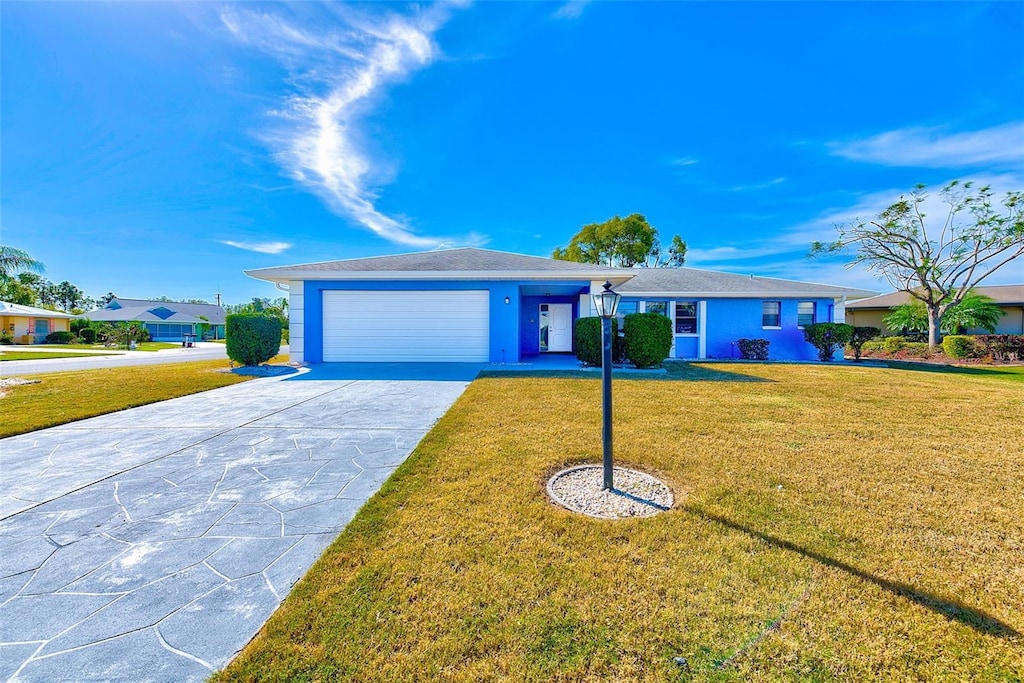 single story home featuring a front lawn and a garage