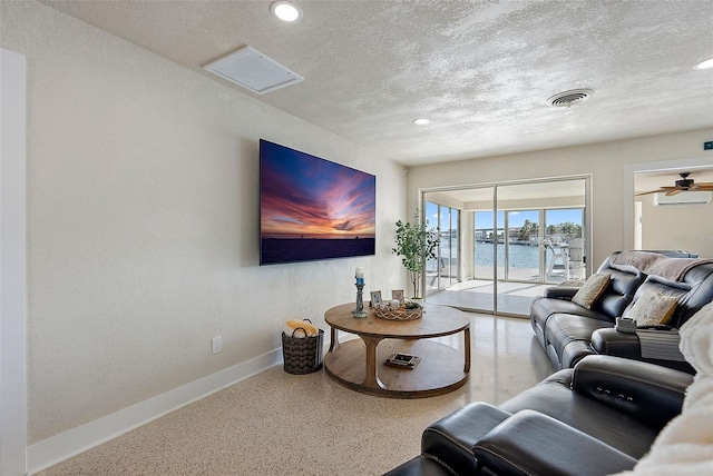 living room featuring a textured ceiling and ceiling fan